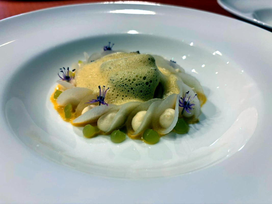 Grillede kamskjell fra Hitra, servert med tindved, syltet kålrot og kamskjellsaus med jalapeño. Foto: Matthew Hope